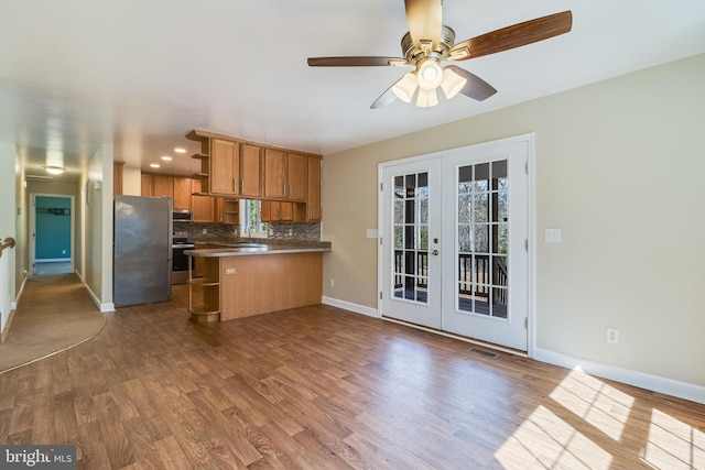 kitchen with backsplash, appliances with stainless steel finishes, french doors, brown cabinetry, and open shelves