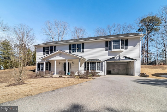 view of front of property featuring an attached garage, covered porch, and driveway