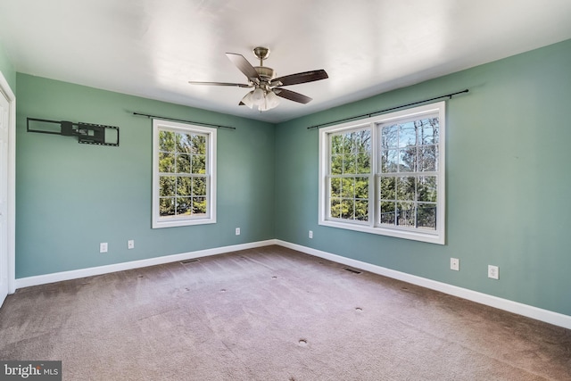 unfurnished room with visible vents, baseboards, carpet floors, and a ceiling fan