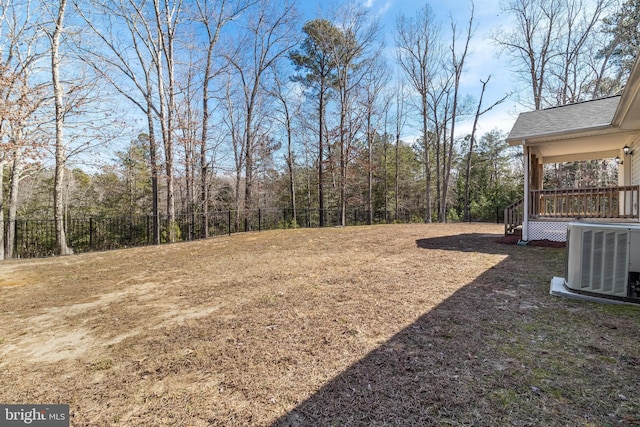 view of yard with a deck, central air condition unit, and a fenced backyard