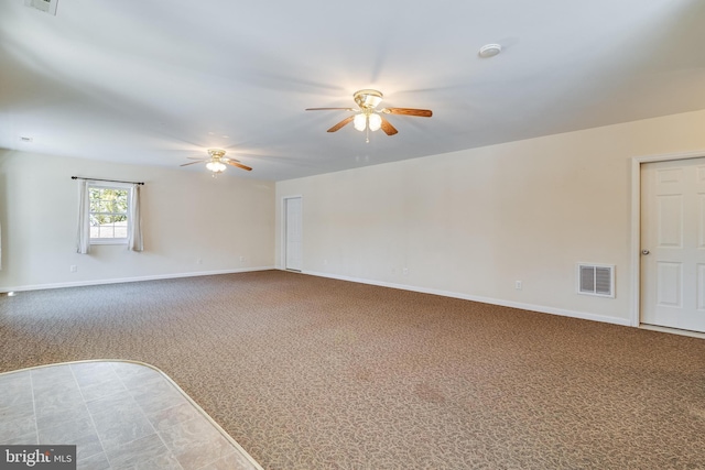 spare room featuring visible vents, baseboards, a ceiling fan, and carpet flooring