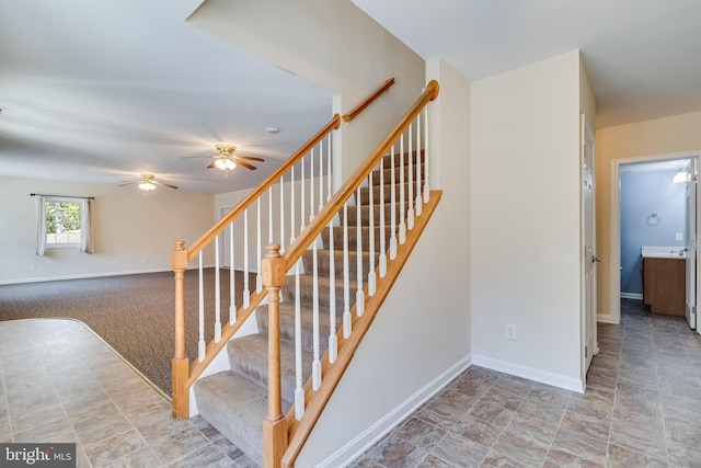 stairs featuring ceiling fan and baseboards