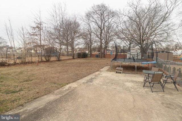 view of yard with a shed, a trampoline, and a patio