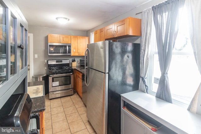 kitchen featuring a wealth of natural light, stainless steel appliances, light tile patterned floors, and light brown cabinets