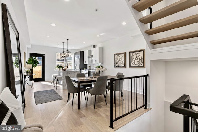 dining room featuring a notable chandelier, light hardwood / wood-style flooring, and sink