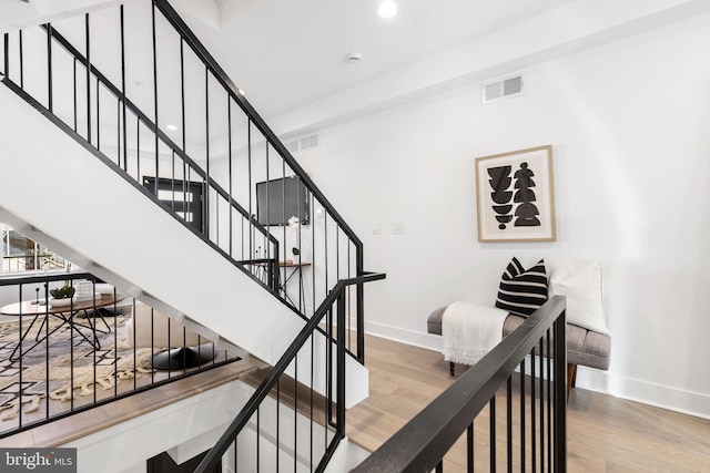 stairs featuring hardwood / wood-style flooring and a high ceiling