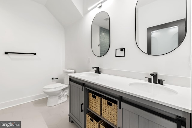 bathroom featuring lofted ceiling, vanity, and toilet