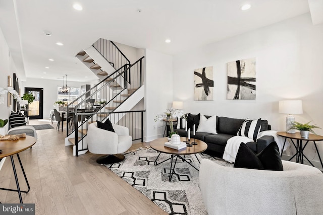 living room featuring a chandelier and light wood-type flooring