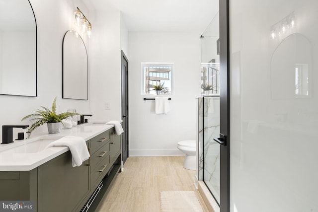 bathroom featuring vanity, hardwood / wood-style floors, walk in shower, and toilet