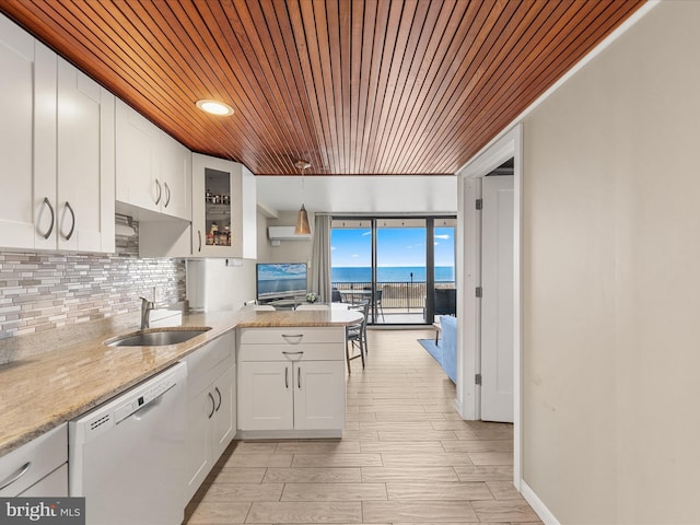 kitchen featuring sink, white cabinetry, tasteful backsplash, hanging light fixtures, and dishwasher