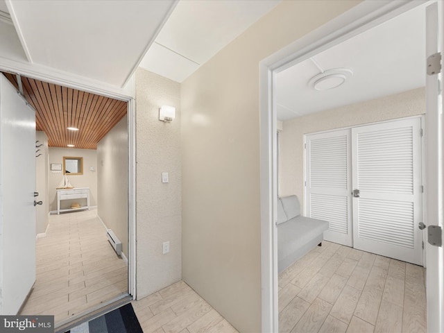 hallway featuring a baseboard heating unit and light hardwood / wood-style flooring