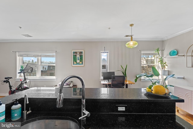 kitchen with pendant lighting, sink, a wealth of natural light, and ornamental molding