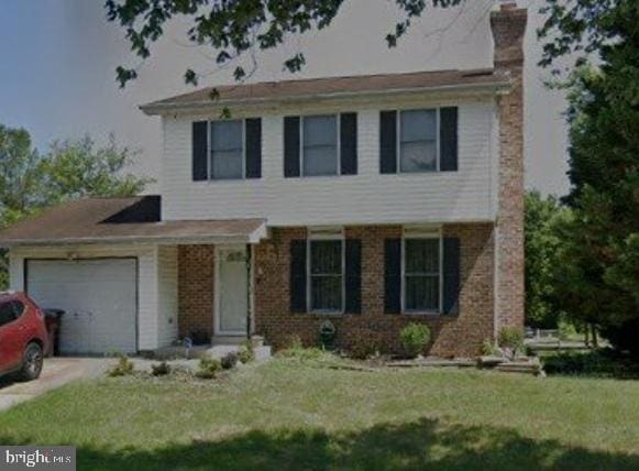 view of front of house with a garage and a front lawn