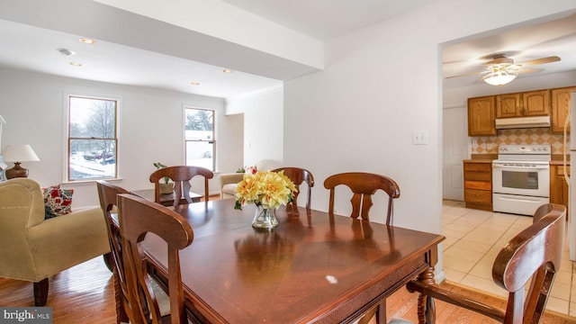 dining area featuring crown molding, light tile patterned floors, and ceiling fan