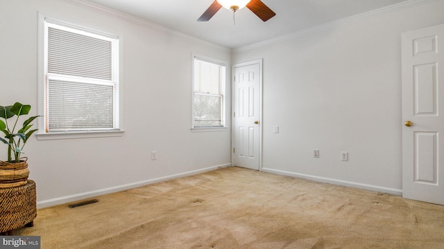 empty room featuring ornamental molding, light carpet, and ceiling fan