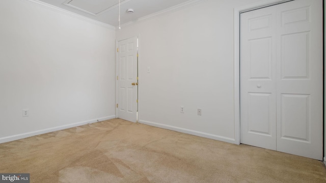 unfurnished bedroom with light carpet, crown molding, and a closet