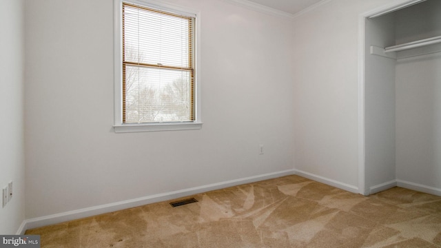 unfurnished bedroom with crown molding, light colored carpet, and multiple windows