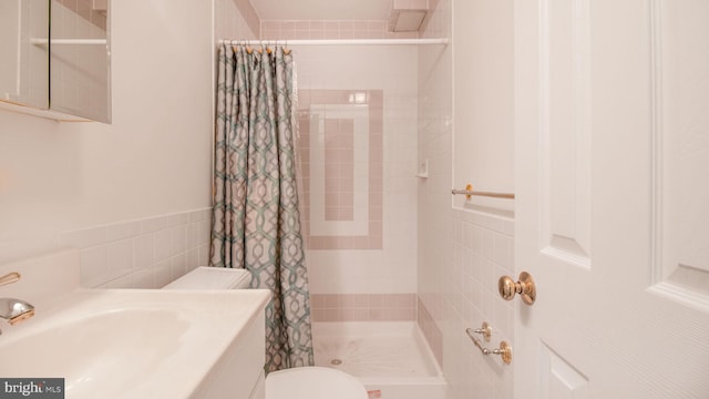 bathroom featuring a shower with curtain, toilet, and tile walls