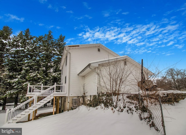 snow covered property with cooling unit