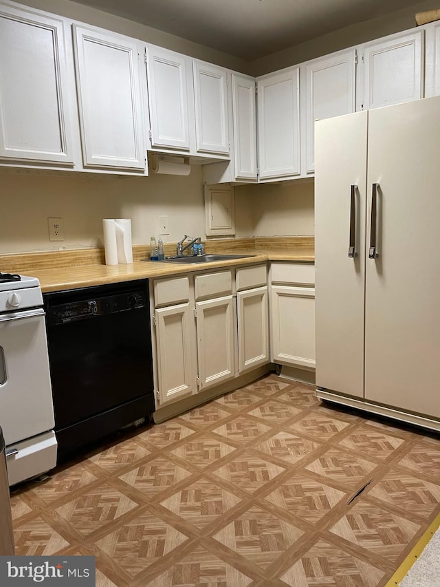 kitchen featuring white cabinetry, sink, light parquet flooring, and white appliances