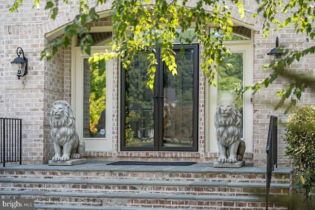 view of exterior entry featuring brick siding