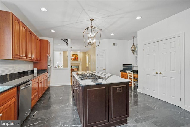 kitchen featuring marble finish floor, a kitchen island, a glass covered fireplace, recessed lighting, and appliances with stainless steel finishes