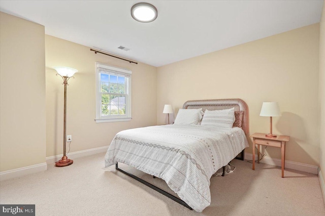 carpeted bedroom featuring baseboards and visible vents