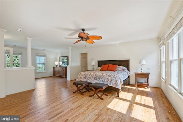 bedroom with baseboards, light wood-style floors, and decorative columns