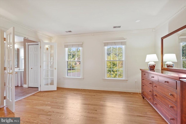 bedroom with visible vents, baseboards, light wood-style floors, french doors, and crown molding