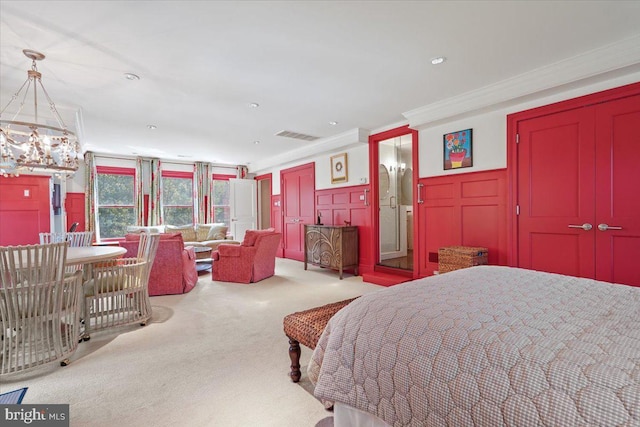 bedroom featuring visible vents, ornamental molding, a decorative wall, wainscoting, and carpet flooring