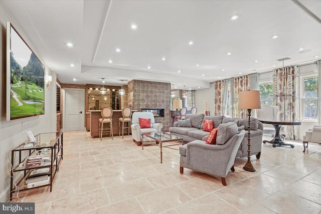 living room featuring a fireplace, recessed lighting, and stone tile flooring