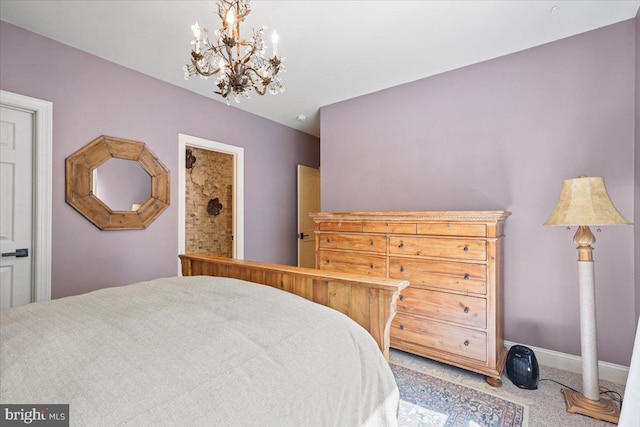 carpeted bedroom featuring a notable chandelier and baseboards