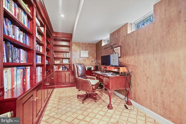 home office with baseboards and built in shelves