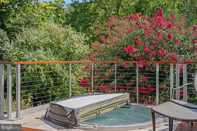 view of patio featuring a covered hot tub and a balcony