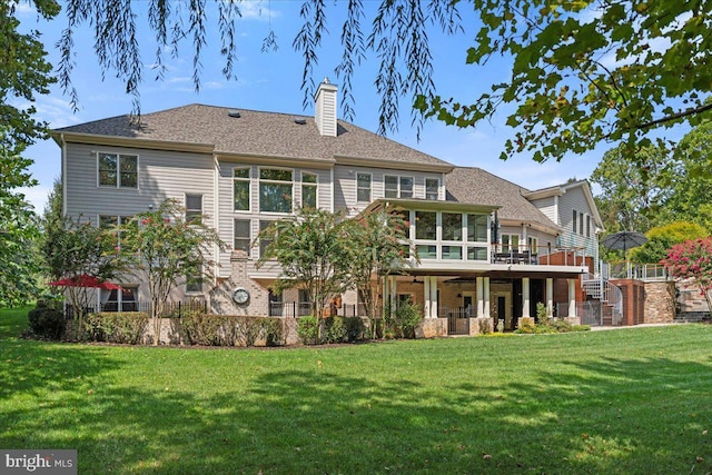 rear view of property with stairway, a sunroom, a chimney, a deck, and a yard