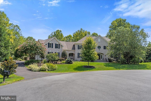 view of front facade featuring a front lawn and stone siding