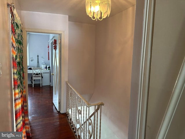 hall with an inviting chandelier and dark wood-type flooring