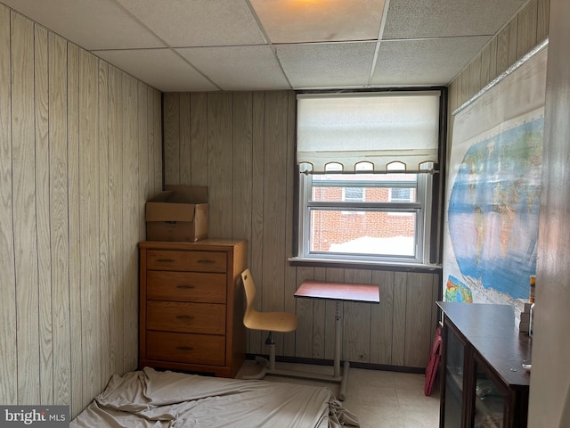 misc room featuring wood walls and a drop ceiling