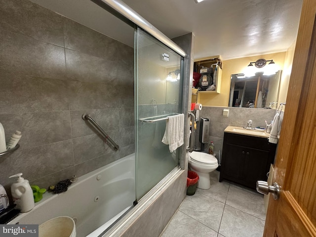 full bathroom with tile patterned floors, toilet, bath / shower combo with glass door, tile walls, and vanity