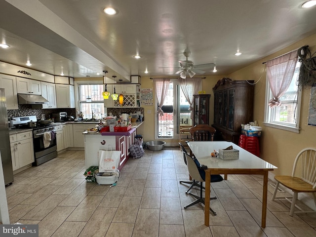 kitchen featuring hanging light fixtures, backsplash, white cabinets, and appliances with stainless steel finishes