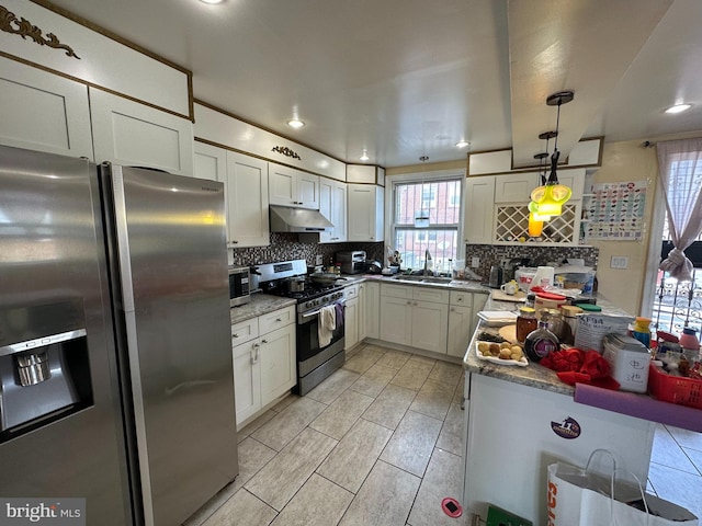 kitchen featuring pendant lighting, white cabinetry, backsplash, light stone counters, and stainless steel appliances