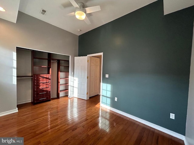 unfurnished bedroom with wood-type flooring, ceiling fan, and a closet