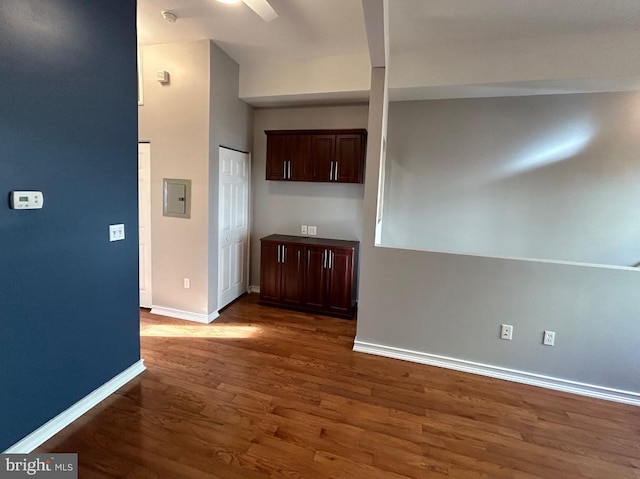 interior space featuring dark brown cabinets, dark wood-type flooring, electric panel, and ceiling fan