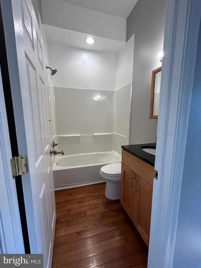 full bathroom featuring hardwood / wood-style flooring, vanity, toilet, and shower / bathing tub combination