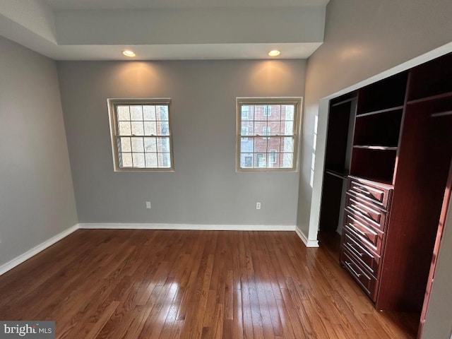 unfurnished bedroom with multiple windows and wood-type flooring