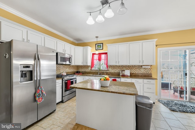 kitchen with a kitchen island, appliances with stainless steel finishes, hanging light fixtures, and white cabinets