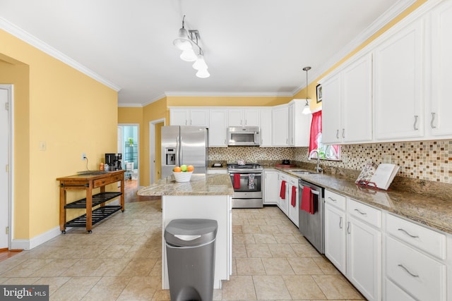 kitchen with sink, a center island, appliances with stainless steel finishes, pendant lighting, and white cabinets