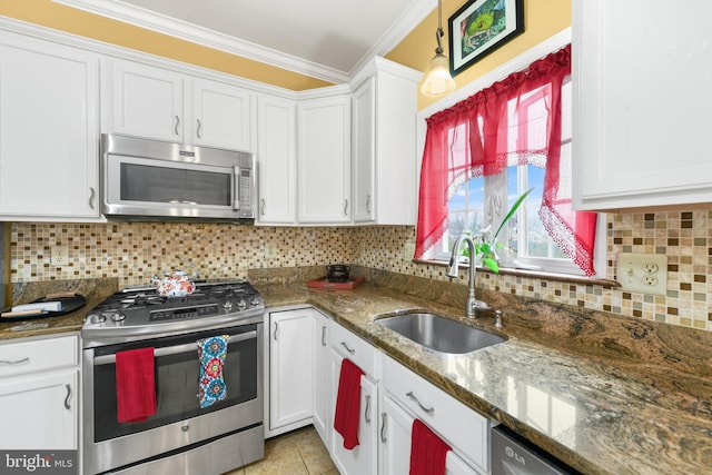 kitchen featuring sink, white cabinets, dark stone counters, stainless steel appliances, and crown molding