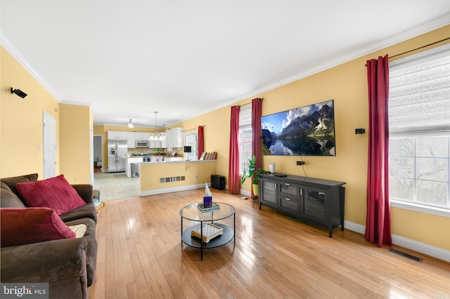 living room with crown molding and light hardwood / wood-style floors