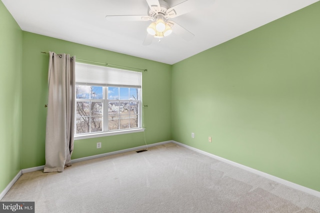 carpeted spare room with ceiling fan